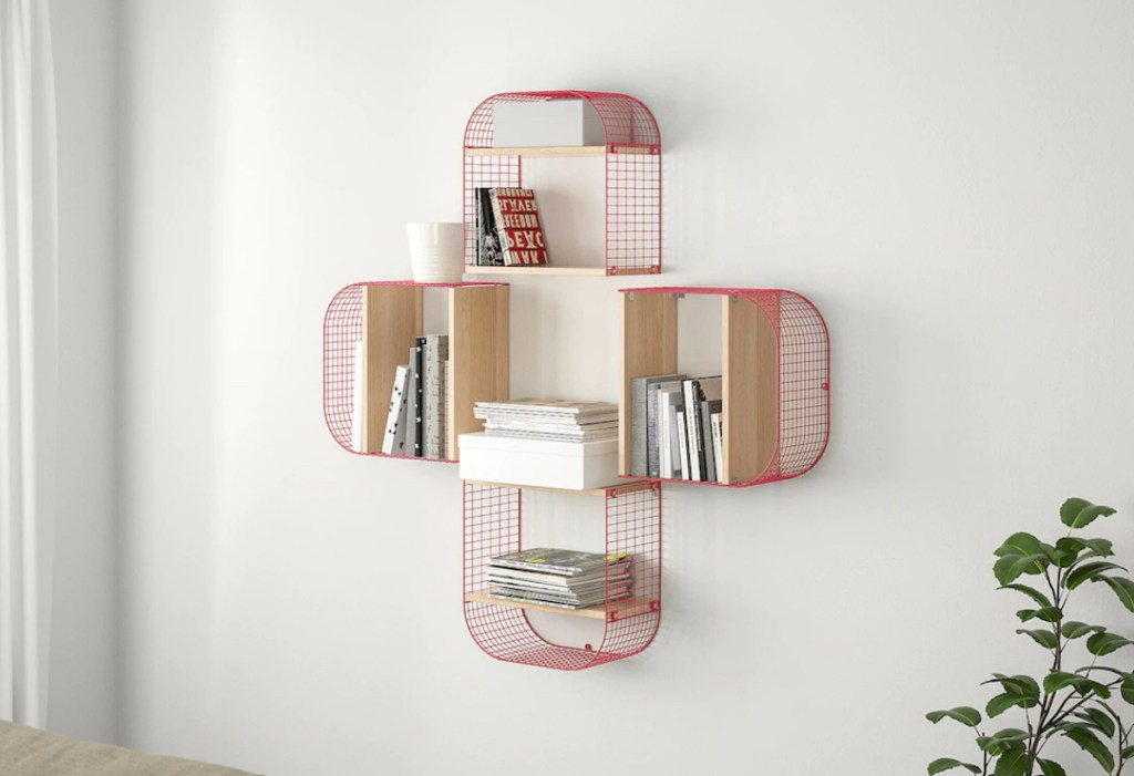 four red wire shelves on wall with books